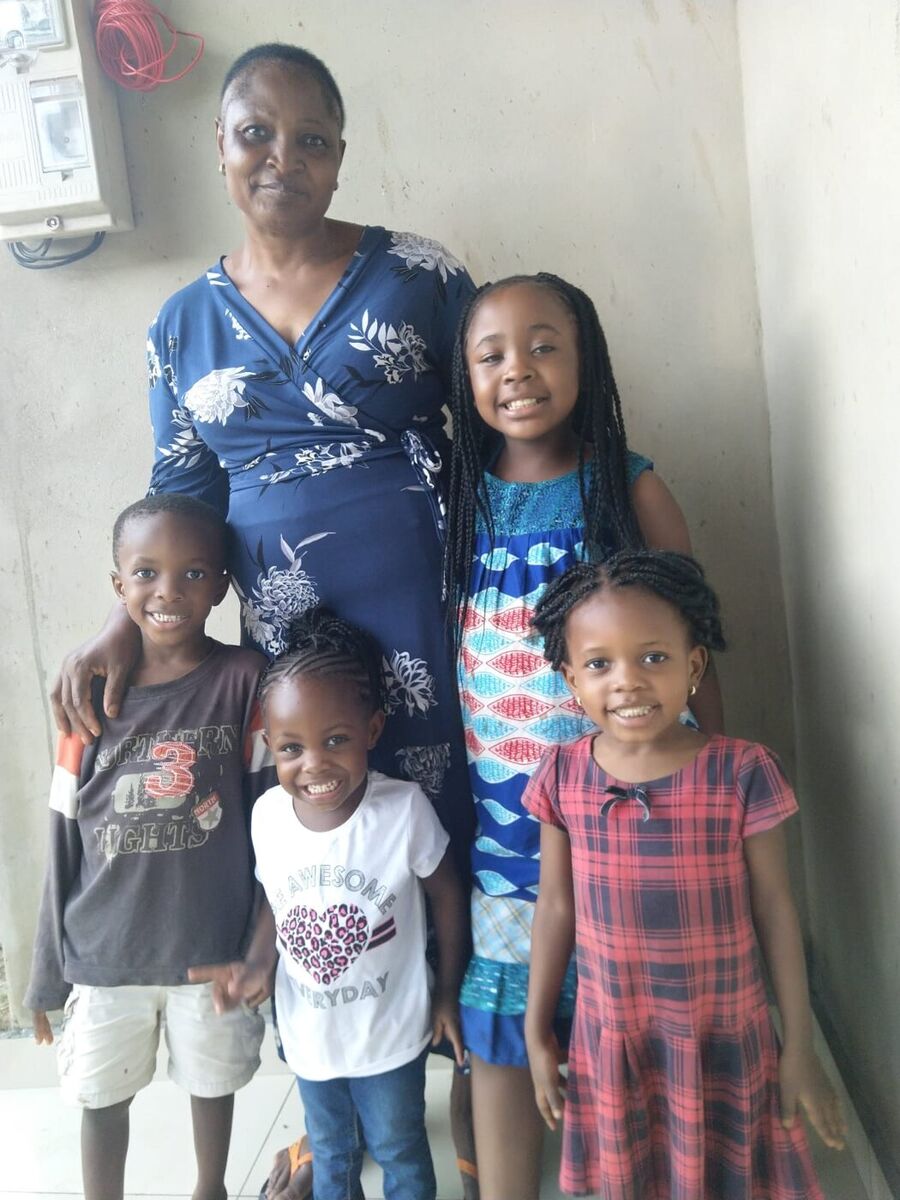 Maman Marie-Claire en robe bleue avec quatre petits-enfants